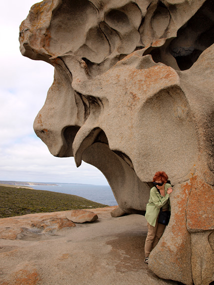 Visitor standing next to huge rocks